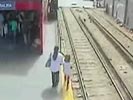 Mother drops girl on the train track seconds before a train comes.