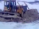 Bulldozer on frozen lake cracks through ice.